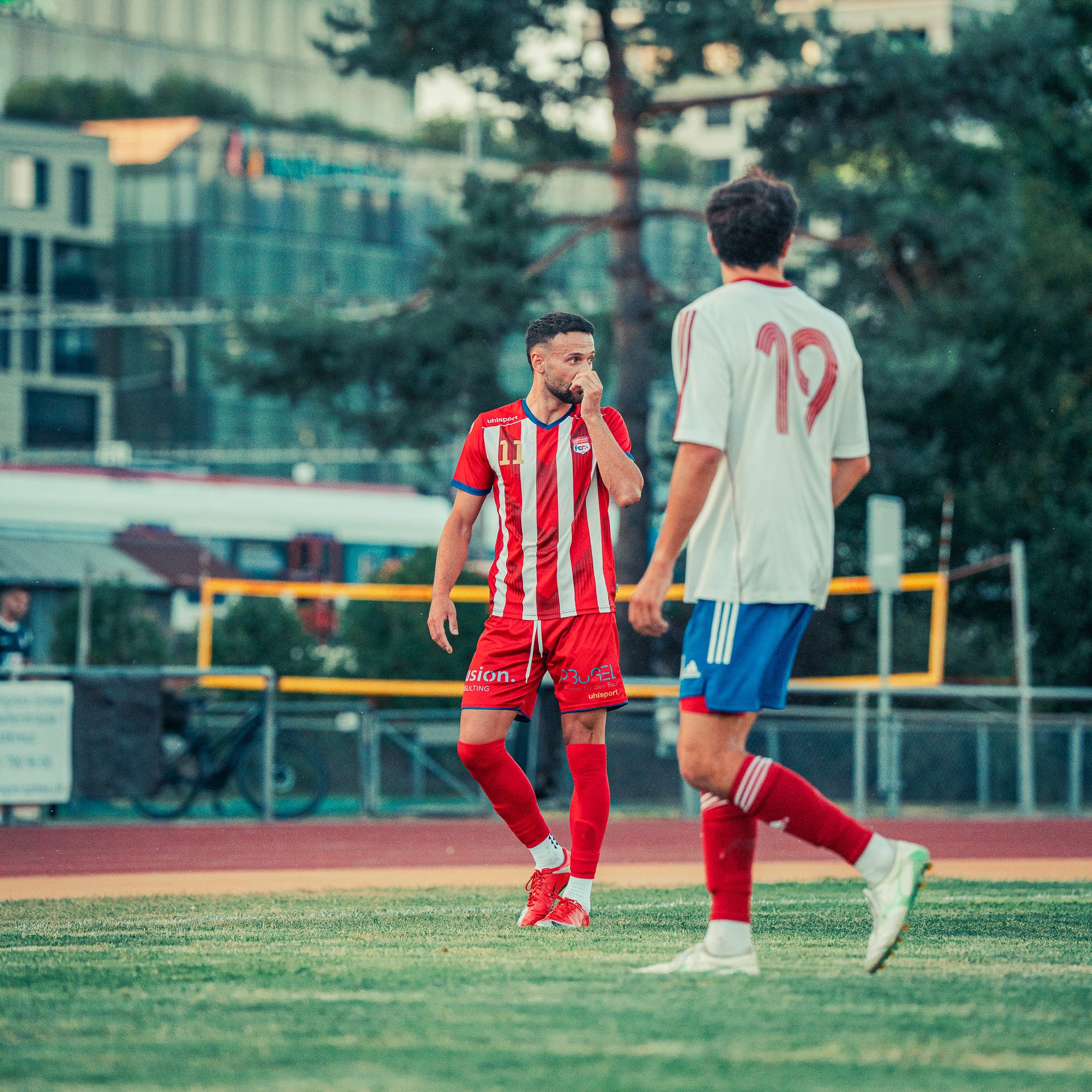 Zwei Fussballspieler im Gespraech auf dem Platz